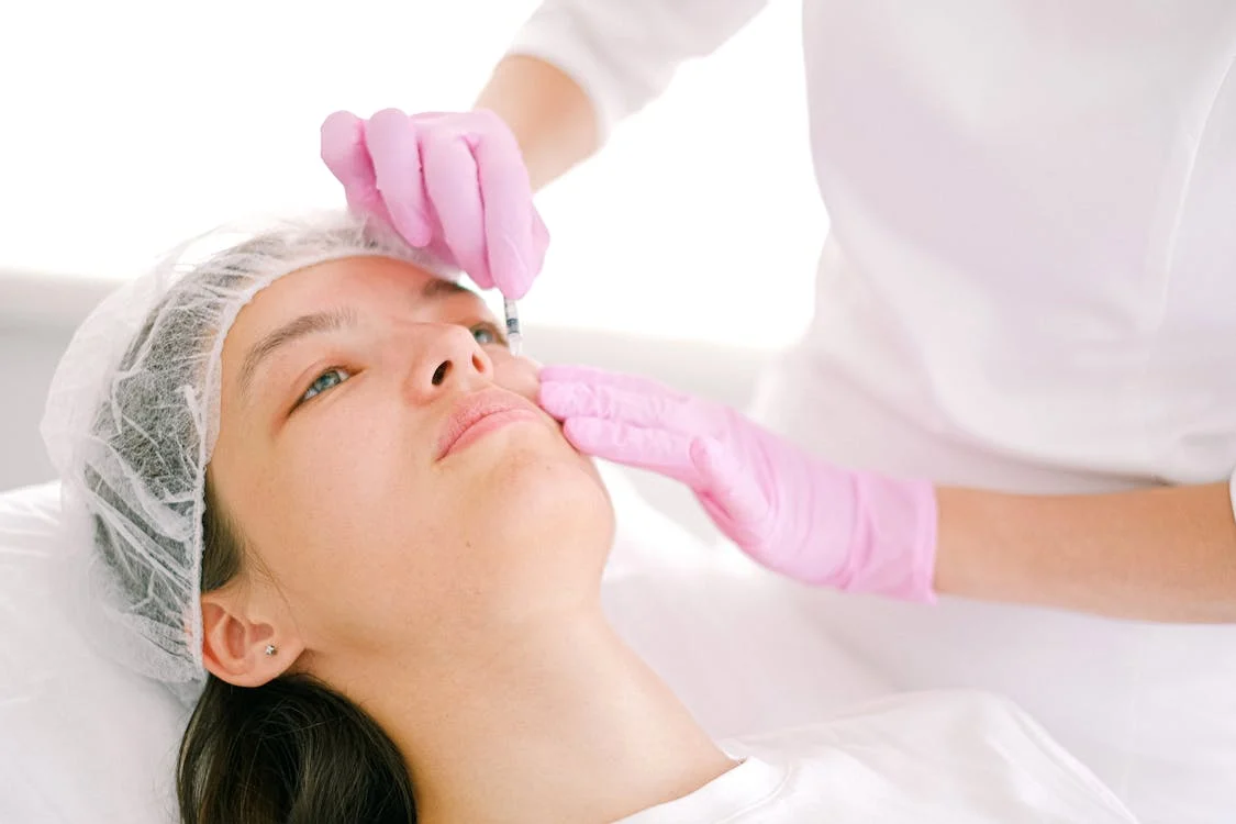 Professional administering Botox injection to a woman at a med spa.